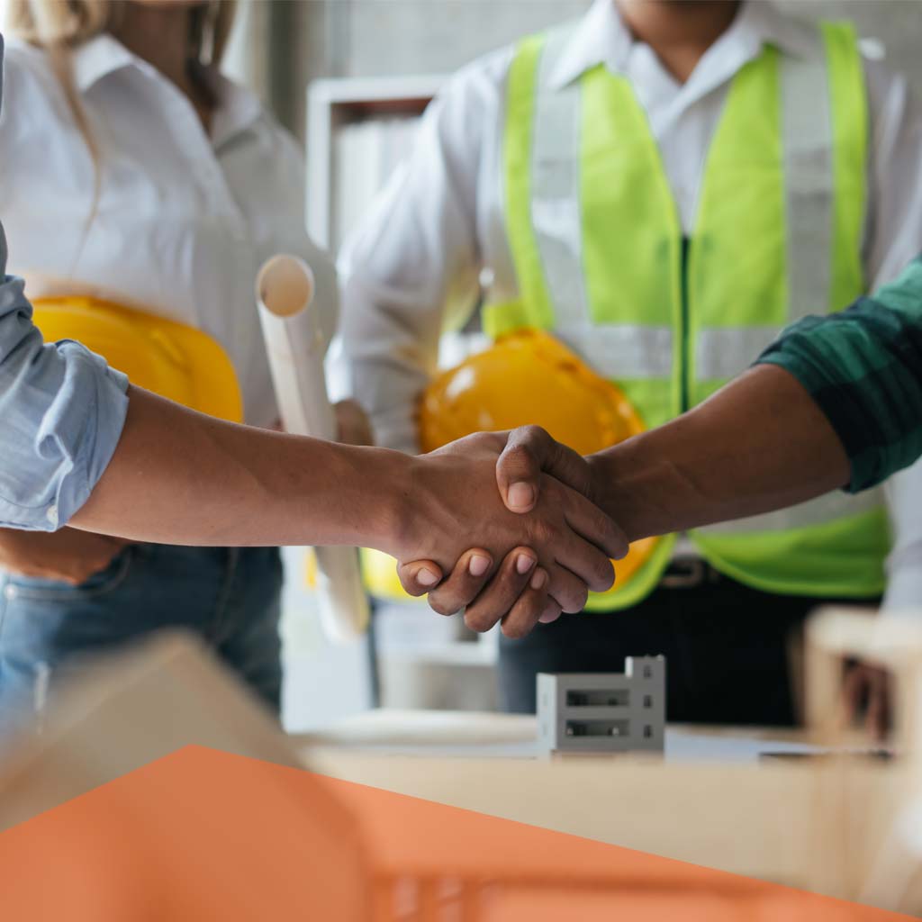 Handshake between professionals in construction, with hard hats and plans, symbolizing collaboration and staffing solutions in skilled trades.